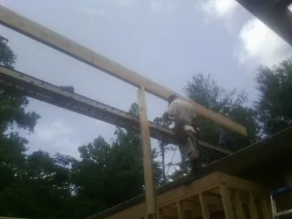 Carpenter setting a ridge beam over a new addition frame — Ice Dam Removal by Roofing Brothers in Steamboat Rock