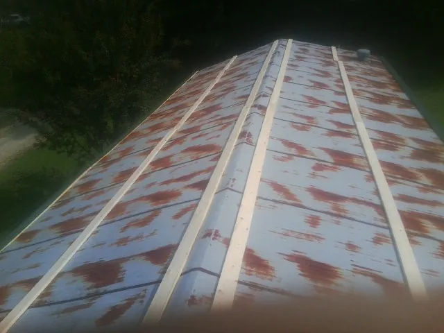 Rusted metal roof panels with new wood purlins before replacement — Storm Damage Roof Repair in Steamboat Rock by Roofing Brothers
