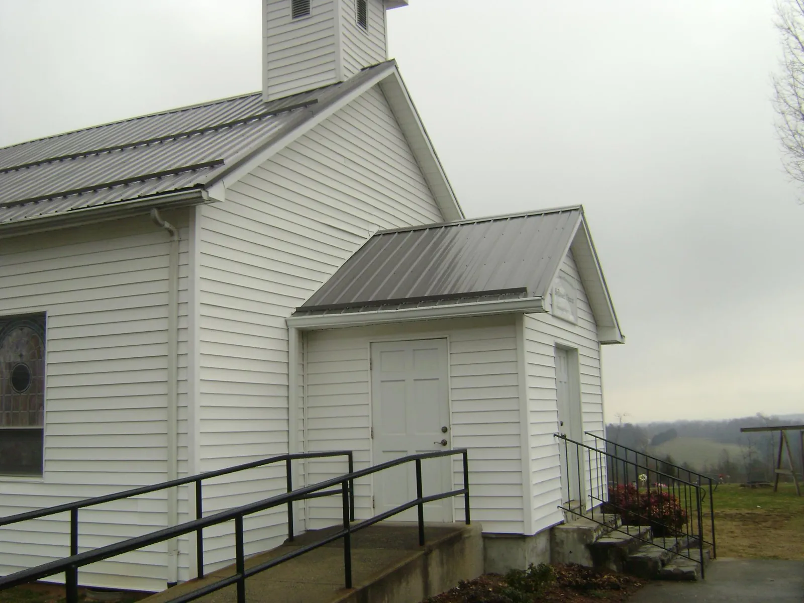 Gray metal roof on a white clapboard church with a steeple in Steamboat Rock