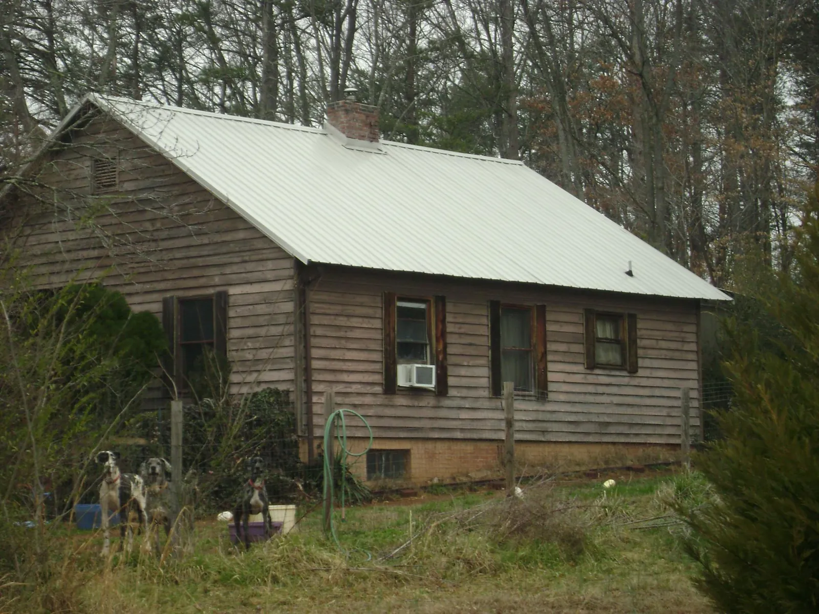 White metal roof on an old wood sided farmhouse, from a Metal Roof Installation job in Steamboat Rock